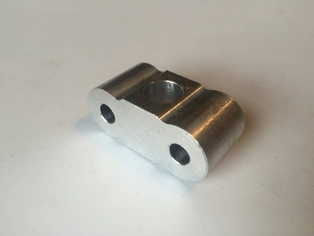 The axle housing. The axles fit through the two smaller holes, and the stem is fit into the large central hole.