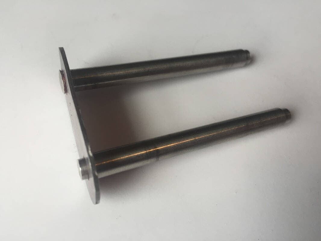 The axles assembled into the plates. One of them is peened so the metal mushrooms out around the axle plate.